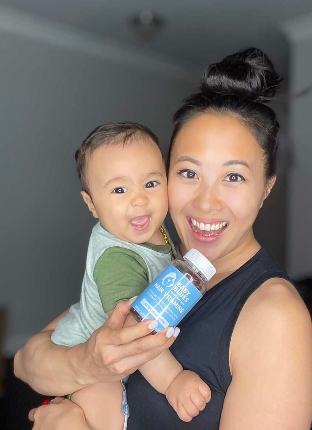 Baby Blues Postpartum Hair Loss Vitamins Gummies next to a glass of water